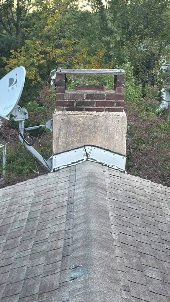 Older shingles and chimney flashing on the Chalfont roof before replacement