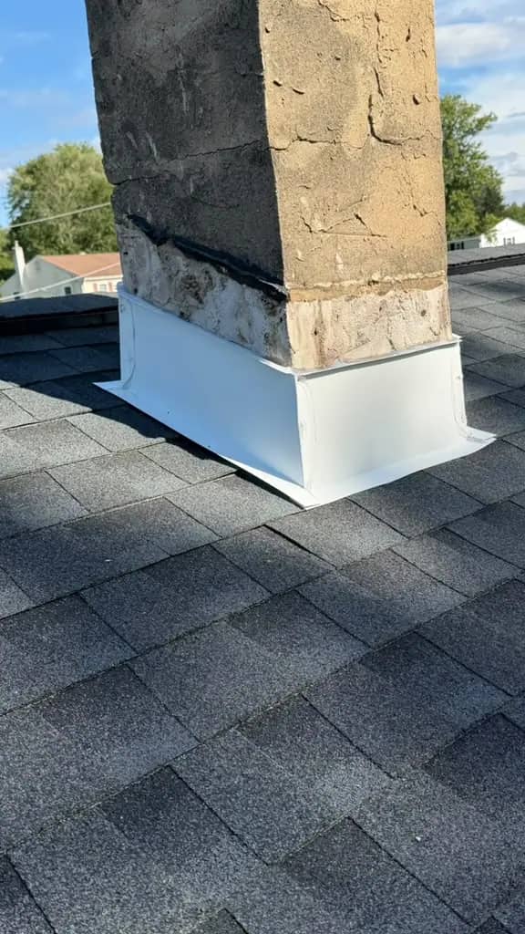 White new flashing at a Chalfont chimney base surrounded by Charcoal shingles
