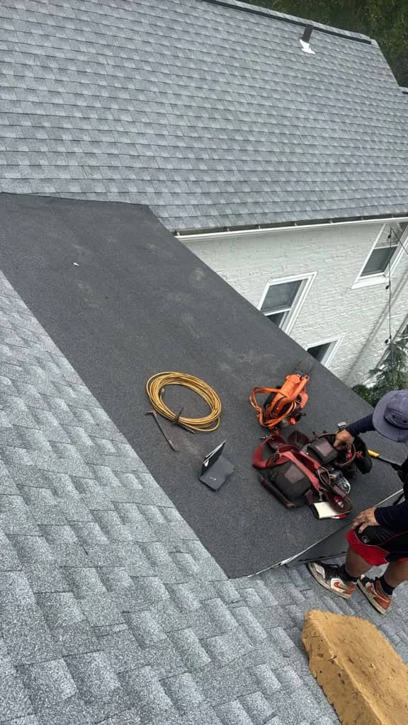 Completed shingle roof beside a low-slope roof section in Penn Wynne