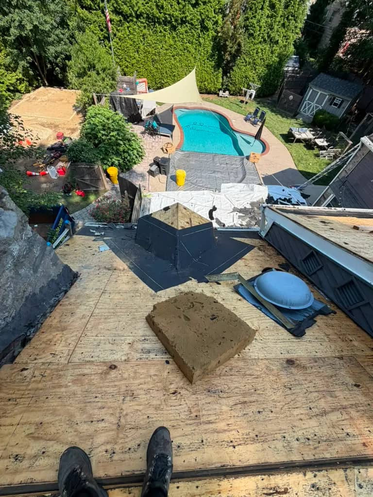 Exposed roof decking beside a stone chimney during the Penn Wynne project