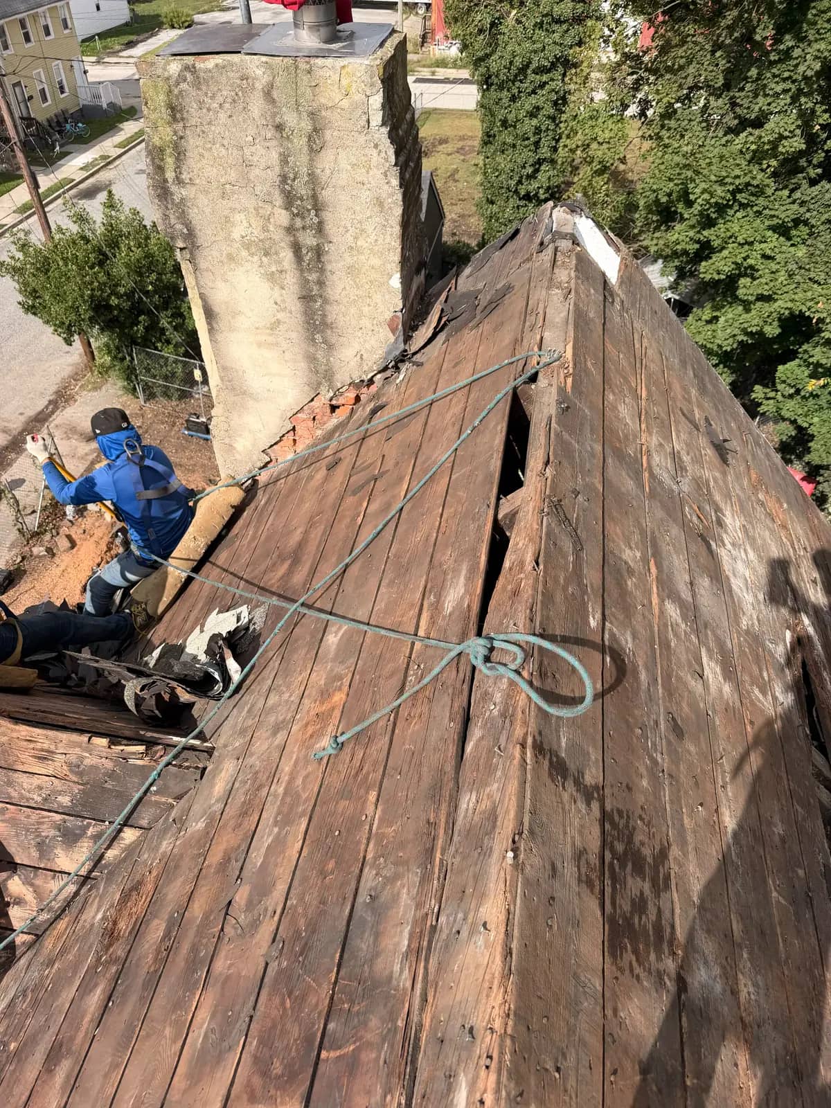 Older wood decking exposed beside the chimney during Salem roof tear-off