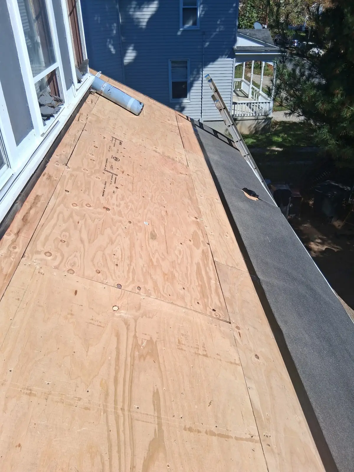 Replacement plywood along a lower Salem roof section beside the house windows