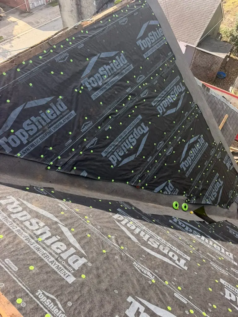 Underlayment fastened across intersecting roof sections during the Salem installation
